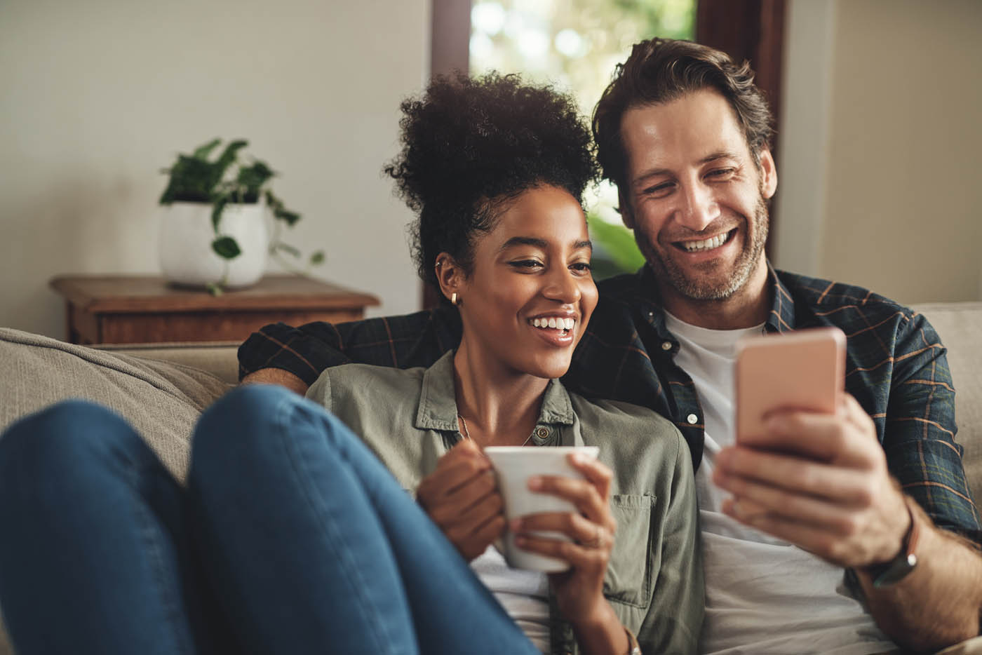 A couple sitting on a couch enjoying a pest free home, check out our Rest Easy Pest Control Suffolk County, NY faqs.